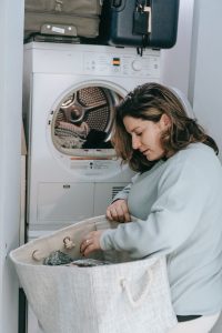 Una mujer pone ropa sucia en el lavarropas