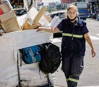 Recuperadora de residuos en la calle con su carro repleto de cartón.