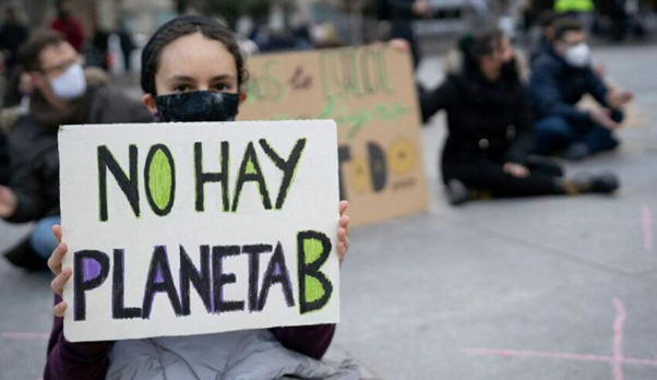 Joven con un cartel que expresa "NO HAY PLANETA B"